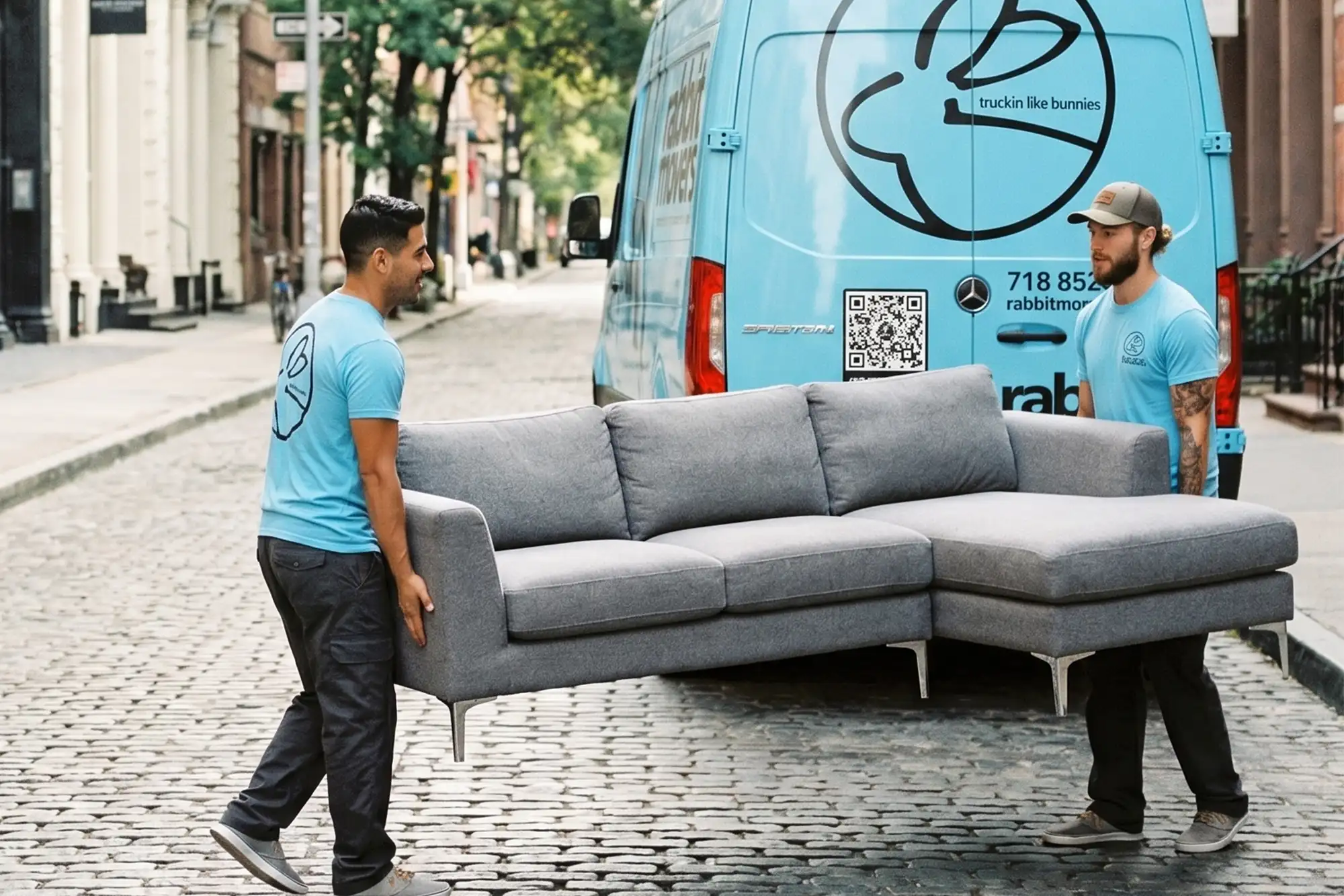 Rabbit Movers crew carrying a sofa on a New York street